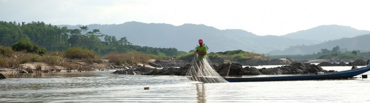 A man standing on a canoe with a fishing net 